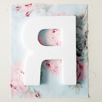 1) Cut a fabric square a few centimetres larger than your letter.
