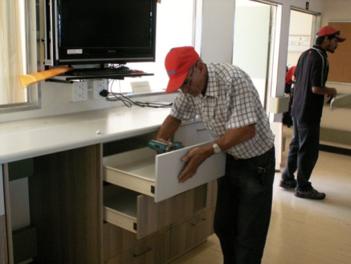 An Easylife Kitchens employee working hard at putting the Ward’s new Quick Access Station together.